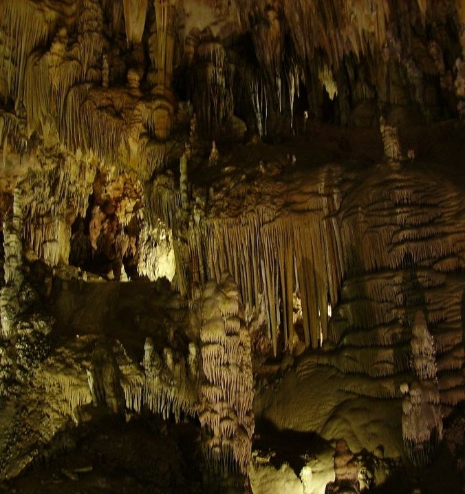 Inside a cave with dramatic stalactites and rock formations near La Cala