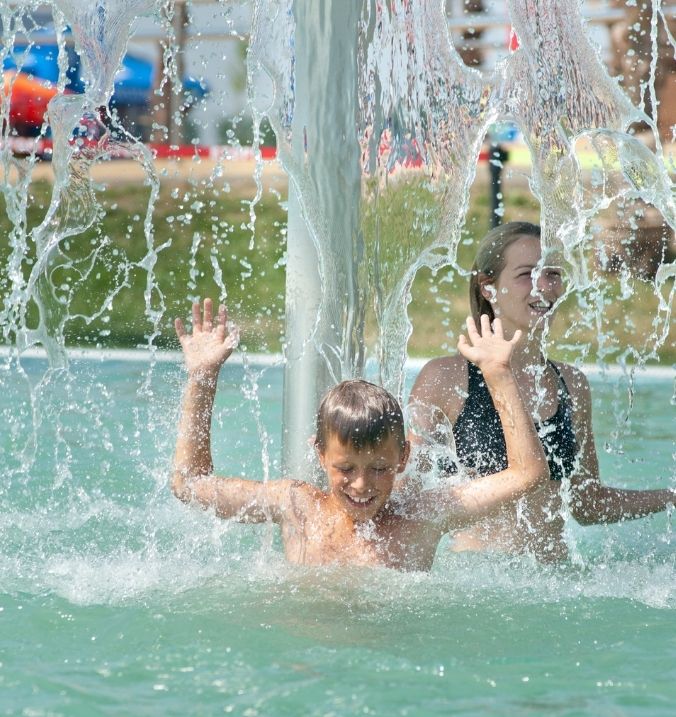 Kids playing under a water fountain at La Cala’s water park